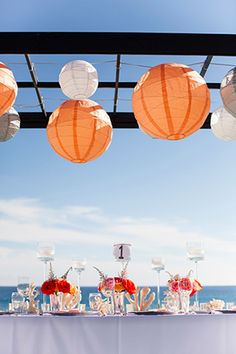 the table is set with paper lanterns and flowers