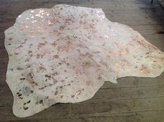 a white and brown area rug sitting on top of a wooden floor