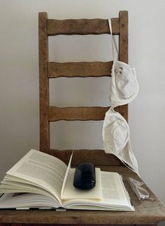 an open book sitting on top of a wooden chair