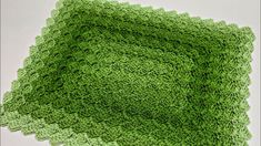 a green crocheted dishcloth on a white surface