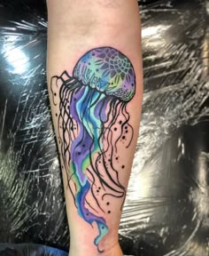 a colorful jellyfish tattoo on the arm