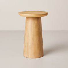 a small wooden stool sitting on top of a white floor