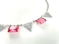 "Beautiful Art Deco era pink and silver choker necklace. The rectangular stones are bezel set in etched silver metal (probably rhodium plated). They are strung between triangular shaped filigree elements and the necklace is finished with a paperclip chain (this one is actually called a peanut or crinkle chain, but all were popular in the 30s). The fish hook clasp was added by me. CONDITION/MEASUREMENTS: Excellent vintage condition. The sterling fish hook clasp was added by me (it was missing a h Vintage Pink Sterling Silver Jewelry, Pink Vintage Sterling Silver Jewelry, Pink Sterling Silver Vintage Jewelry, Vintage Pink Jeweled Necklace, Vintage Pink Sterling Silver Necklace, Nickel-free Pink Metal Necklaces, Vintage Pink Choker Necklace, Pink Nickel-free Metal Necklace, Pink Choker Jewelry For Formal Occasions