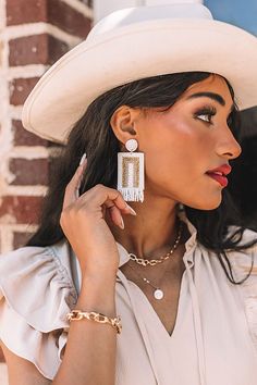 All eyes are sure to be on you when you accessorize with our stunning 'Malibu Pier' statement earrings featuring white and gold beaded circle studs, dangling rectangle pieces, and fringe detailing! White Bohemian Tassel Earrings For Party, Bohemian White Tassel Earrings For Party, Bohemian White Beaded Earrings, White Beaded Fringe Tassel Earrings For Beach, White Beaded Fringe Dangle Jewelry, White Fringe Tassel Drop Earrings, White Fringe Beaded Dangle Earrings, Gold Beach Jewelry With Beaded Fringe, White Drop Tassel Earrings For Beach