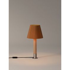 a lamp that is on top of a white surface with a cord attached to it