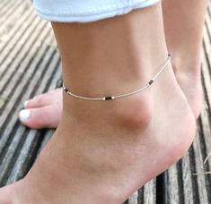 This set of 2 minimalist ultra thin anklet is made of:- One minimalist ultra thin anklet made with sterling silver snake chain adorned with black miyuki beads ( 3 to 3 )- One thin anklet made with sterling silver snake chain adorned with 15 black and silver miyuki beads on the center. ➵ Perfect to wear alone or for layering with more bracelets.➵ More Anklets : https://www.etsy.com/fr/shop/silverbirdjewels?ref=seller-platform-mcnav&section_id=21837916--*--*--*--*--*--*--*--*--*--*--*--*--*--*--*- Black Silver Anklets, Silver Black Beads Anklets, Silver Anklet With Black Beads, Anklet Designs Silver, Ankle Beads, Payal Designs Silver, Anklet Design, Black Anklet, Silver Chain Anklet