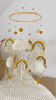 a crib mobile with rainbows and clouds hanging from it