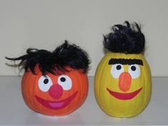 two pumpkins decorated to look like sesame street characters