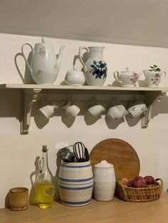 a shelf filled with dishes and cups on top of a wooden table