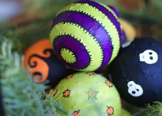 some balls that are sitting on top of each other in the grass with faces painted on them