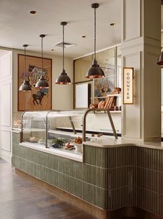 an open kitchen with lots of counter space and lights hanging from the ceiling above it