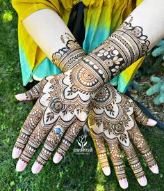 two hands with henna designs on them