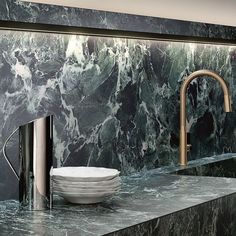 a sink and faucet in a bathroom with green marble wallpaper on the walls