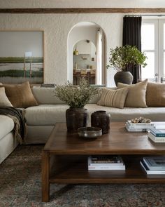 a living room filled with furniture and a coffee table in front of a large window