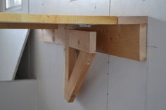 a wooden shelf hanging from the side of a wall