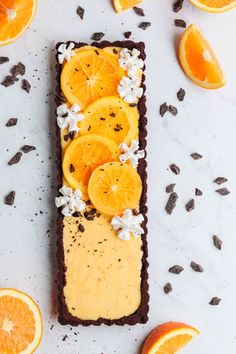 an orange chocolate tart is topped with whipped cream and sliced oranges