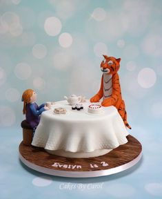 a cake with a tiger sitting at a table