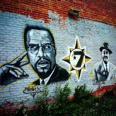 some graffiti on the side of a building with two men in suits and one is pointing at a star