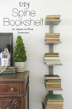 a stack of books sitting on top of a wooden table next to a vase filled with flowers