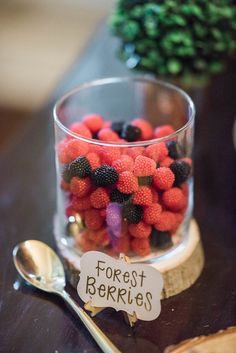 a glass filled with berries sitting on top of a table