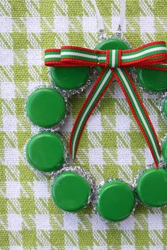 a green bracelet with red, white and green buttons attached to the clasp on a checkered table cloth