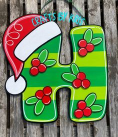 the letter h is decorated with holly berries and a santa's hat on it