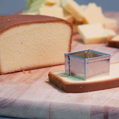 a loaf of bread sitting on top of a cutting board next to a slice of cake