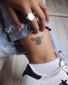 a person with a bee tattoo on their left side of her leg and the other half of her arm