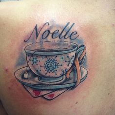 a woman with a tattoo on her back has a cup and saucer in it