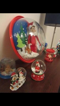 an image of santa clause in a snow globe with other christmas decorations on the table