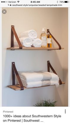 two wooden shelves with towels and soaps on them next to a potted plant