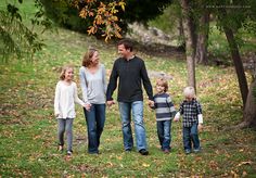 a family walking through the woods holding hands