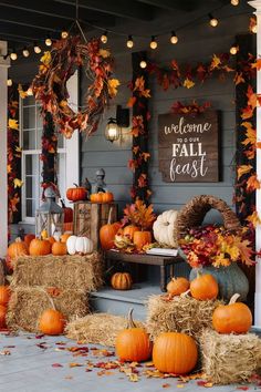 a porch decorated for fall with hay bales and pumpkins