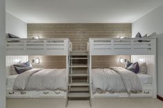 there are two bunk beds with ladders in this room, one is white and the other is gray