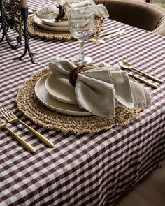 the table is set with plates and silverware, napkins and placemats