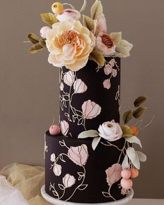 a three tiered cake decorated with flowers and leaves