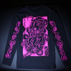 Original and unique designs printed on lightweight black long sleeve sweater with UV reactive neon pink water based ink. An octopus on the front and 4 tentacles along each arm, all featuring spirals and a third eye! Screen printed and retouched by hand. Washed and dried beforehand to ensure durability of the print. Permaset Aqua Supercover brand ink, Gildan brand sweater. I am wearing size medium in the photos. - clothing specs - 4.5 oz./yd² (US) 7.5 oz./L yd (CA), 100% ring-spun cotton, 30 singles Narrow width, rib collar Taped neck and shoulders for comfort and durability Side seams Tear away label Made with OEKO-TEX certified low-impact dyes Long Sleeve Band Merch Top With Screen Print, Long Sleeve Punk Graphic T-shirt, Long Sleeve Punk Tops With Graffiti Print, Long Sleeve Band Merch T-shirt With Screen Print, Punk Long Sleeve Tops With Graffiti Print, Unisex Long Sleeve Band Merch T-shirt, Pink Long Sleeve T-shirt With Graphic Print, Unisex Long Sleeve T-shirt For Streetwear, Unisex Long Sleeve Streetwear T-shirt