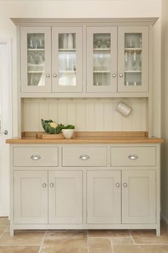 a kitchen with white cupboards and wooden counter tops in the middle of the room