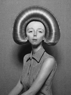 an old photo of a woman with a large metal object on her head and the words odd things above it