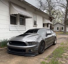 a silver car parked in front of a white house