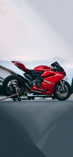 a red motorcycle parked on top of a roof