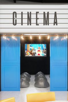 a movie theater with blue doors and yellow chairs