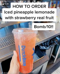 someone is holding up a drink in front of a machine with the words, how to order iced pineapple lemonade with strawberry real fruit