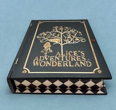 an open book with the title alice's adventures wonderlandland on it sitting on a blue surface