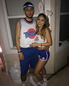 a man and woman standing next to each other in front of a window wearing bunny ears