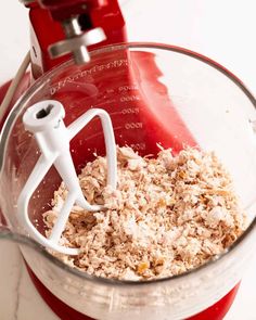 a red blender filled with oatmeal next to a white hand mixer