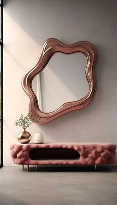 a living room with a pink couch, mirror and vase on the wall next to it