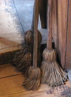 two mop heads sitting on the floor in front of a wooden door with words