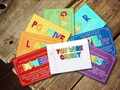 several colorful business cards sitting on top of a wooden table with the words positive written in different languages