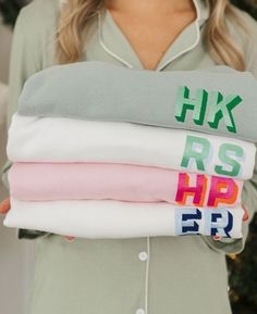 a woman is holding three shirts with the letters r s h p er on them